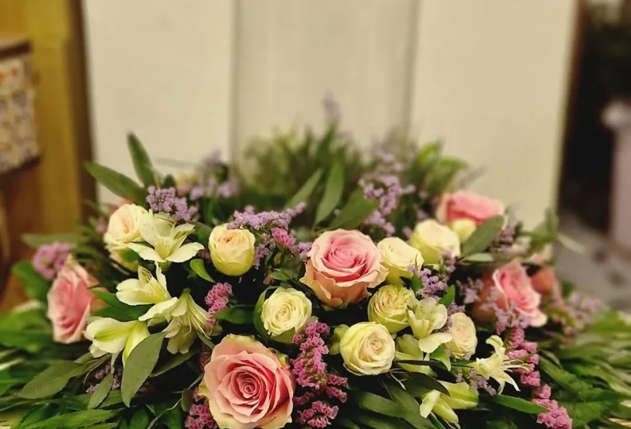 Arreglo pequeño en vaso de cristal con rosas rosa palo y crema