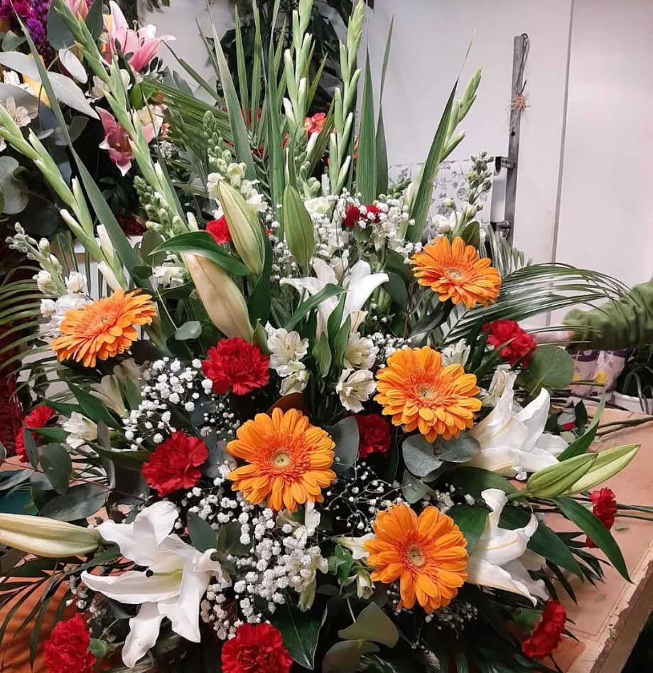 Arreglo grande con gerberas naranjas, lirios blancos y claveles rojos